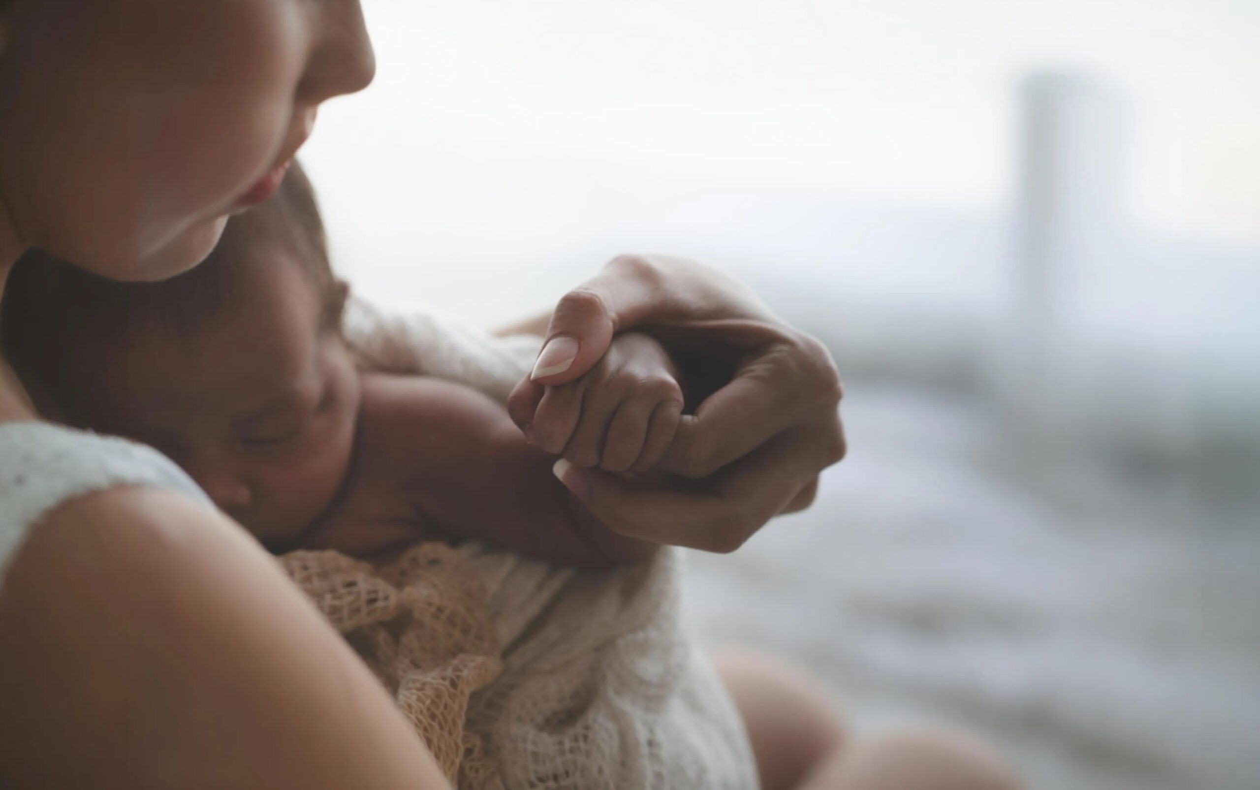 Parent and infant holding hands