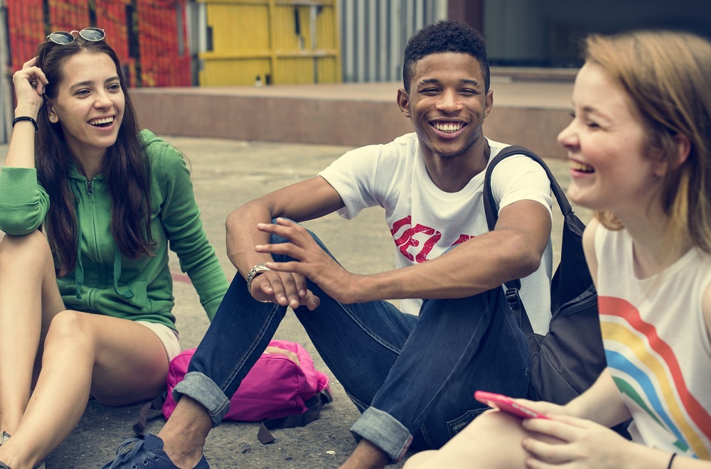 A group of young people sitting on the ground. 