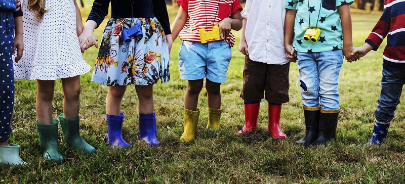 Children holding hands, wearing wellington boots