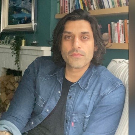 Photograph of Nasif a man with shoulder length dafk hair in a denim shirt