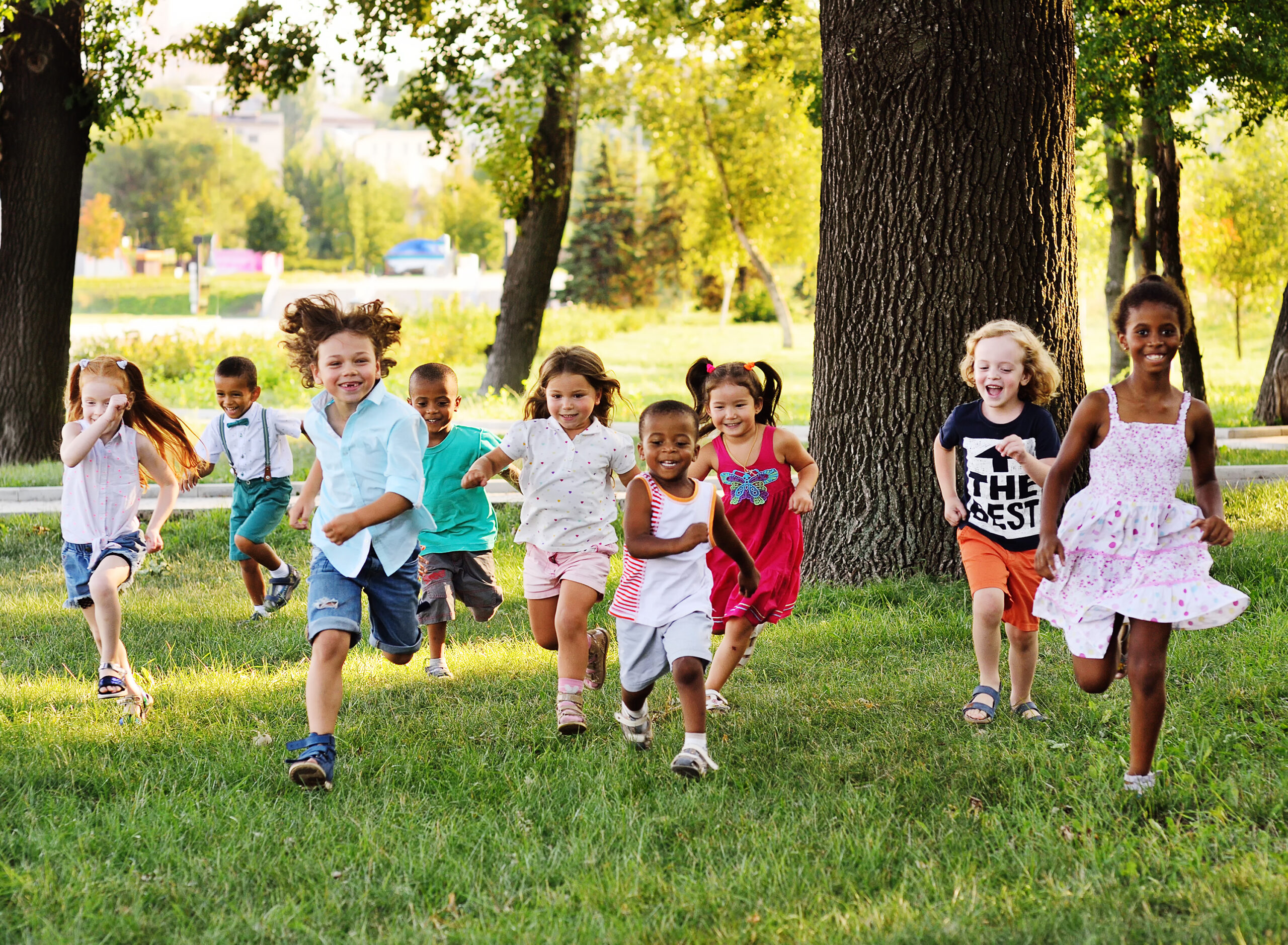 A group of happy children running through the park on a sunny day.