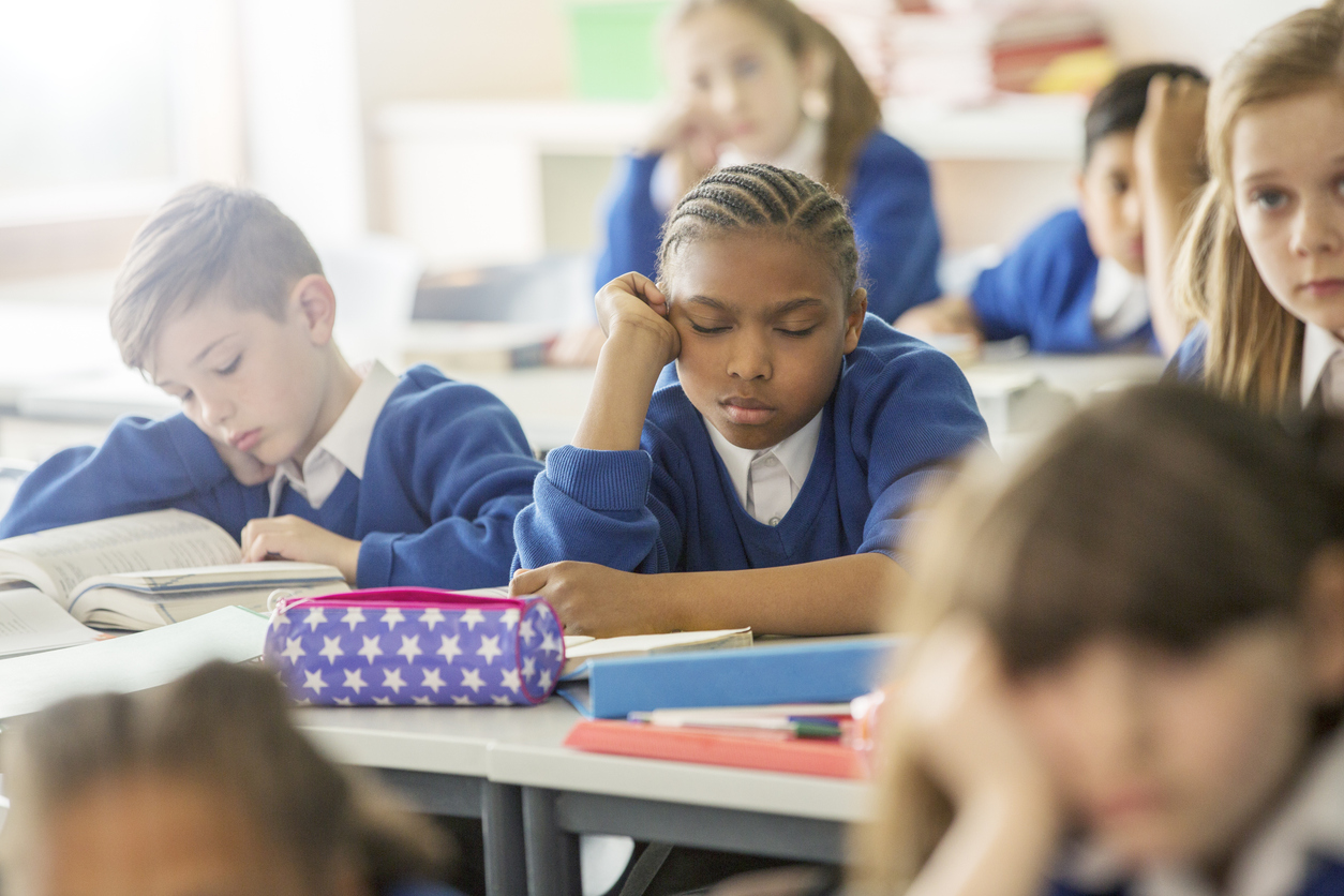 school child asleep and bored in classroom