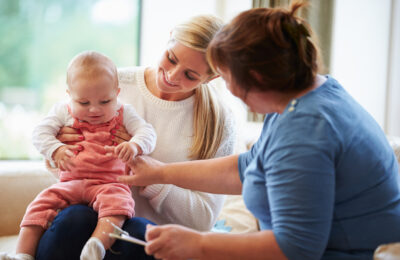 Health Visitor Talking To White Mother With Young Baby