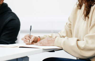 Close-up of student writing in notepad