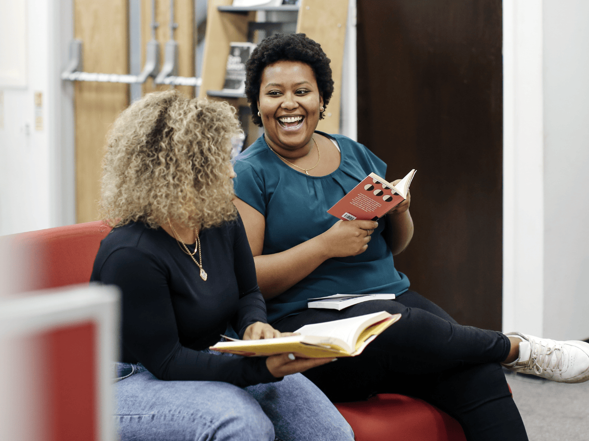 Two students laughing in library