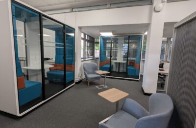 Two group study pods with armchairs outside them, at the rear of the Tavistock Centre library