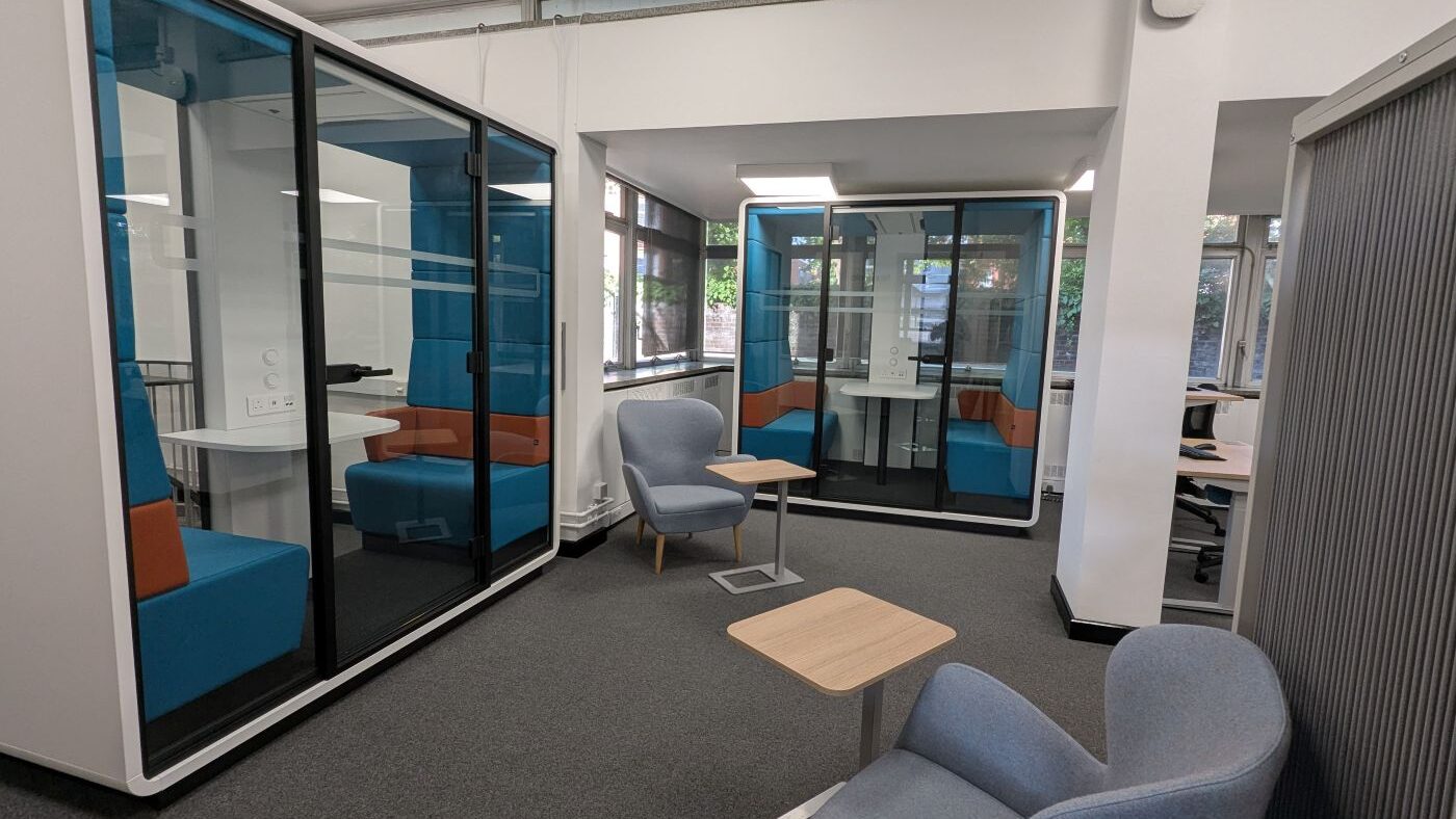 Two group study pods with armchairs outside them, at the rear of the Tavistock Centre library