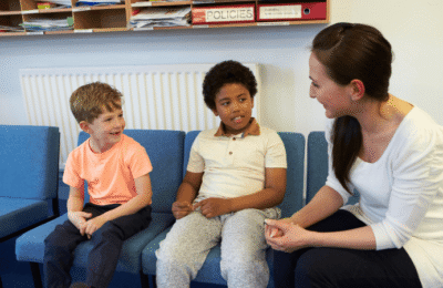 A teacher talking to two children