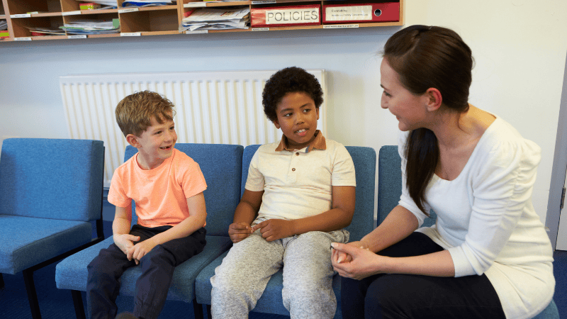 A teacher talking to two children