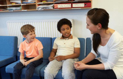 A teacher talking to two children