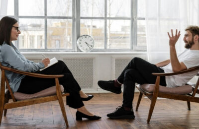 A therapist and a patient sat across from each other in a therapy room.